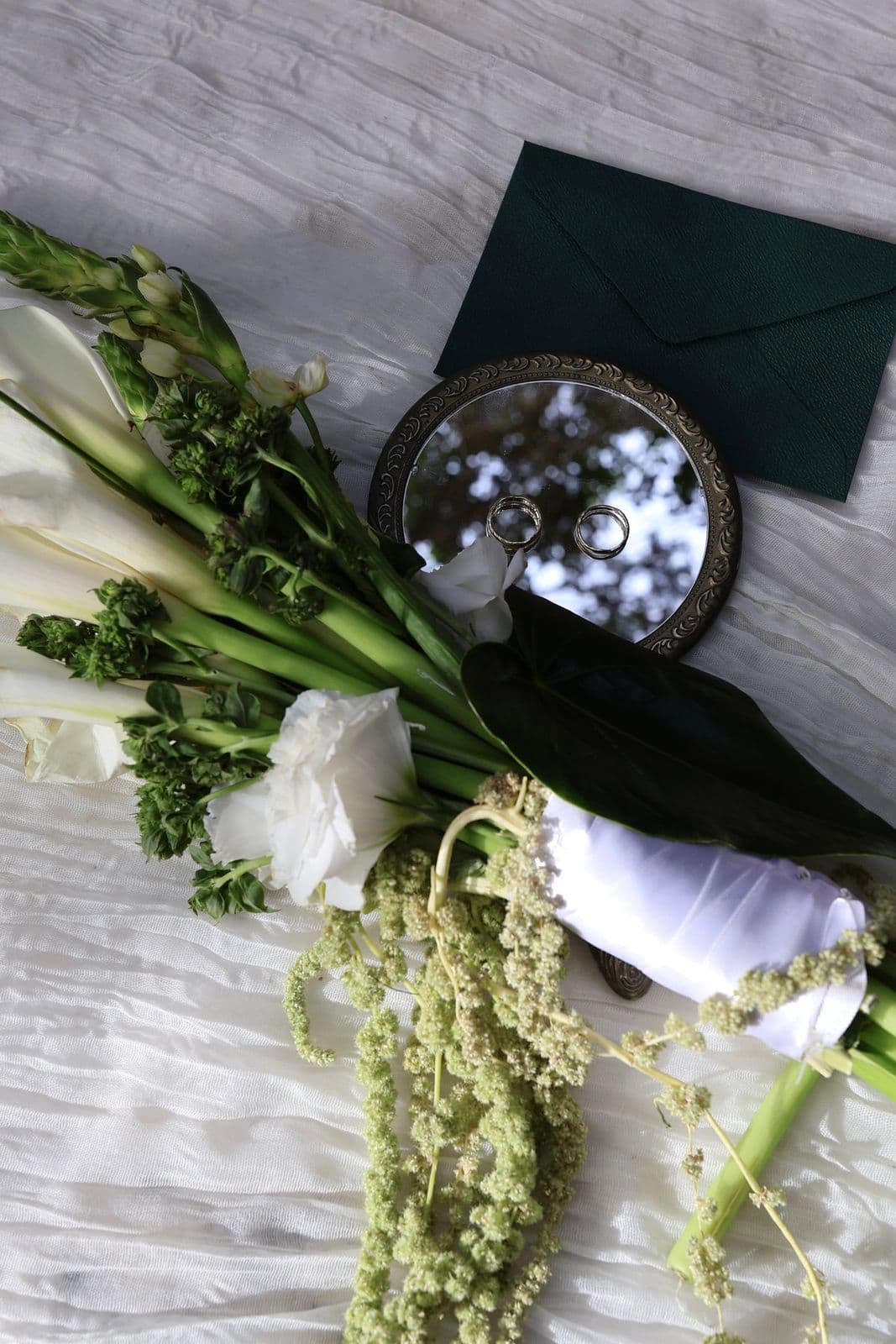 A bouquet of white lilies held against a lace dress
