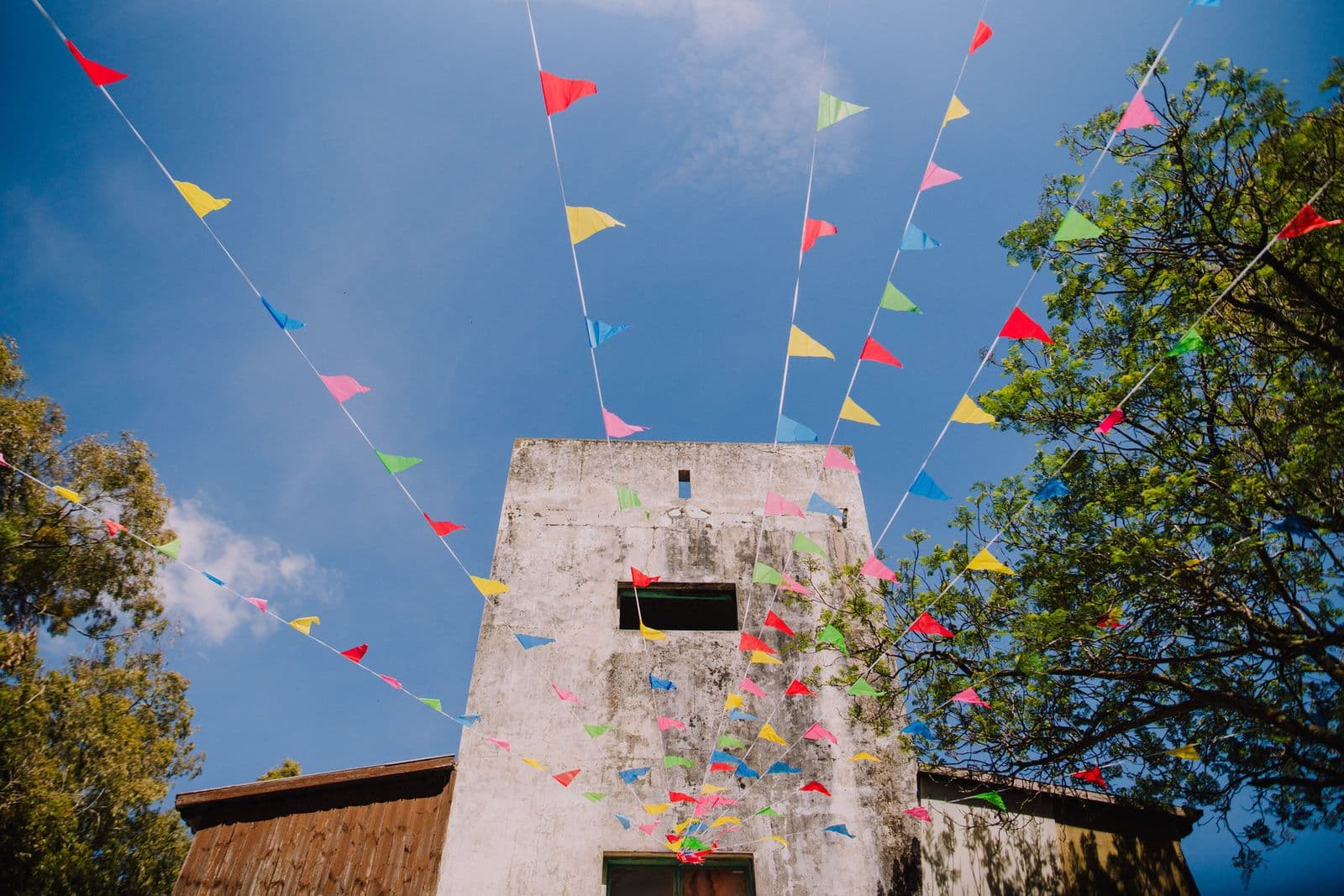 Colourful bunting radiating from an old stone tower against a blue sky