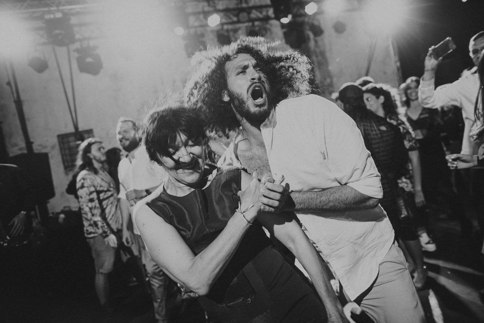 A couple dancing close together, lit by the stage lights